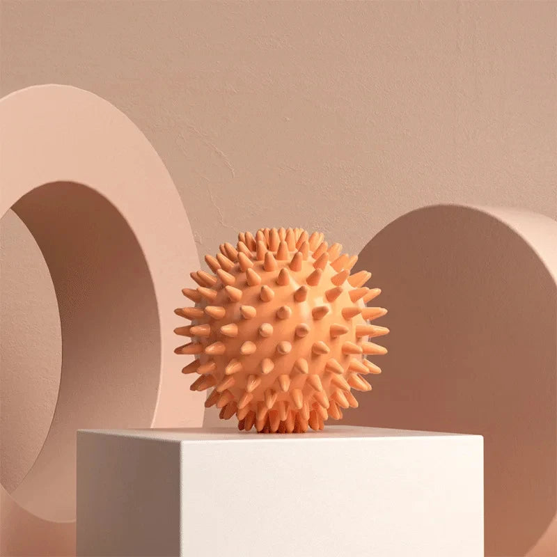 Textured spiky massage ball for muscle relief on a minimalist podium, neutral background