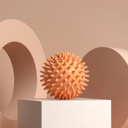 Textured spiky massage ball for muscle relief on a minimalist podium, neutral background