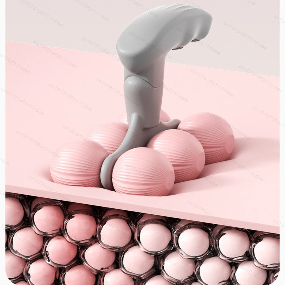 Handheld pink and gray muscle roller massager demonstrating deep tissue massage on skin