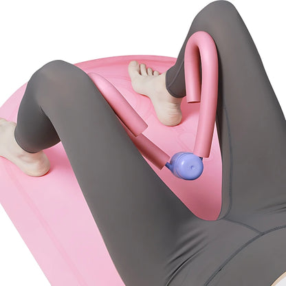 Woman using pink thigh toner fitness equipment on yoga mat, strength training exercise